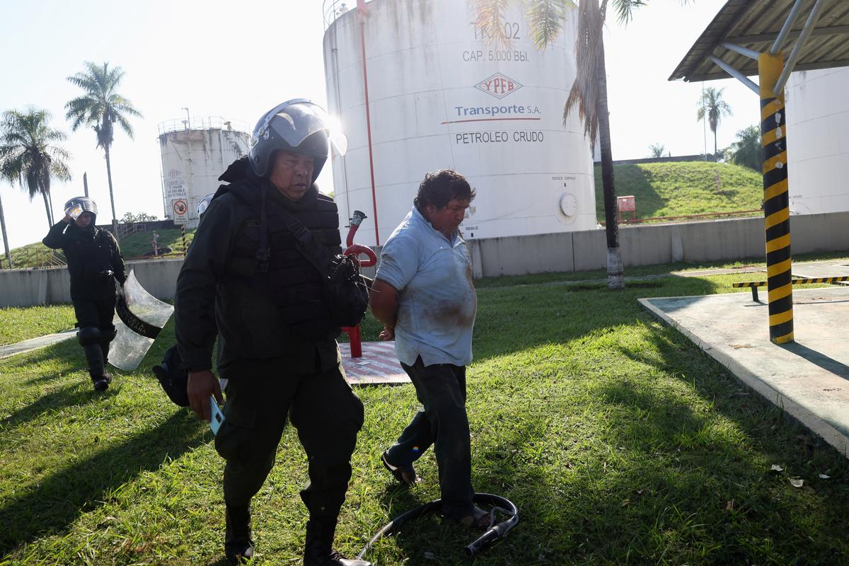 Police officers detain a protester while dislodging community members who seized the Humberto Suarez oil facility to call for the resignation of President Rodrigo Paz, as ongoing protests have led to shortages of fuel and food, in Santa Rosa del Sara, Bolivia June 3, 2026. REUTERS/Ipa Ibanez