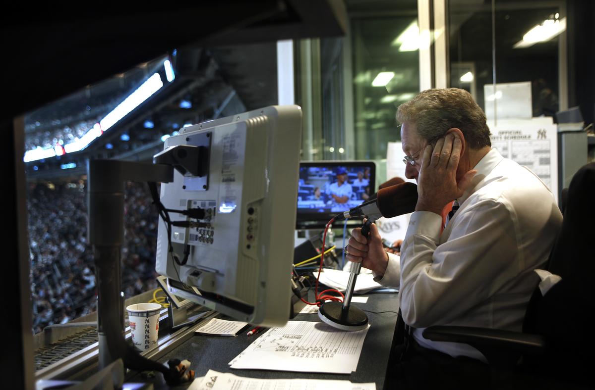 FILE -- John Sterling, the New York Yankees play-by-play announcer for more than 30 years, at work at Yankee Stadium in the Bronx on Sept. 22, 2011. Sterling, who was best known for punctuating his home run calls with colorful -- if not wacky -- phrases like "an A-bomb for A-Rod!" (for Alex Rodriguez) and "Robbie Canó, dontcha know!" (for Robinson Canó), died on Monday. May 4, 2026 in Englewood, N.J. He was 87. (Béatrice de Géa/The New York Times)