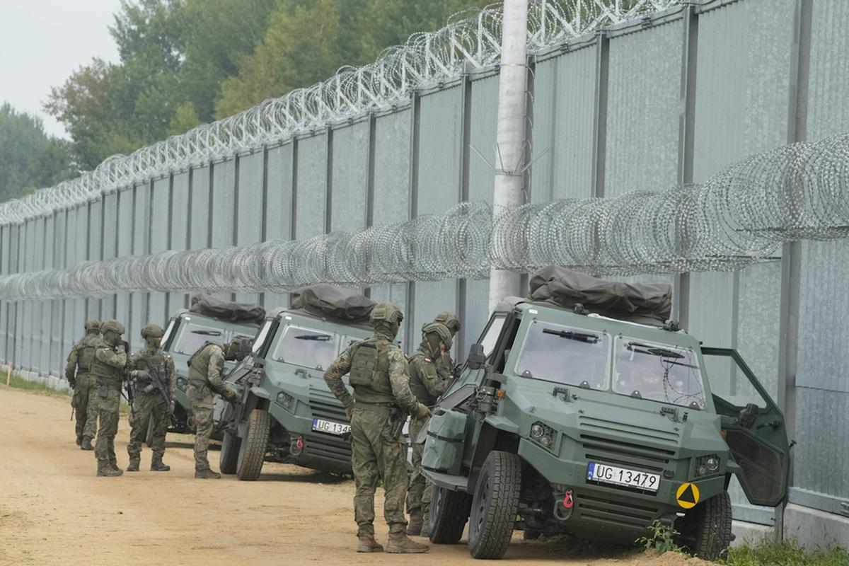  Polish border guards are seen at a fence on the border between Poland and Belarus. AP Photo/Czarek Sokolowski 