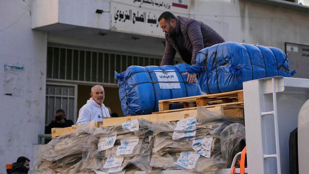A man unloads humanitarian aid supplied by the U.N. refugee agency UNHCR at a school in Beirut used as a shelter for people displaced by Israeli airstrikes. AP Photo/Hassan Ammar. 