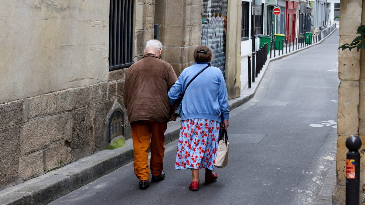 FILE PHOTO: Two older people walk arm-in-arm down a side street in Paris, France, July 14, 2024. REUTERS/Kevin Coombs/File Photo