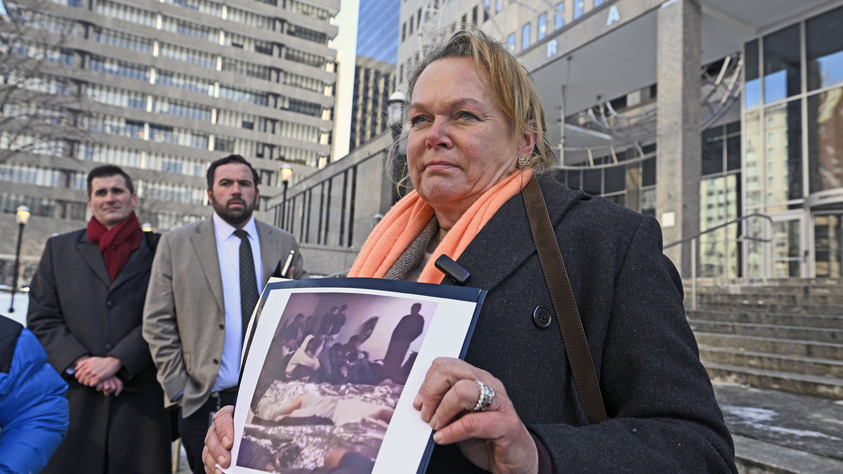 Congresswoman April McClain Delaney shows a picture from a viral video of the ICE detention center in Baltimore while speaking with news media outside the facility. (Kenneth K. Lam/Baltimore Sun/TNS)
