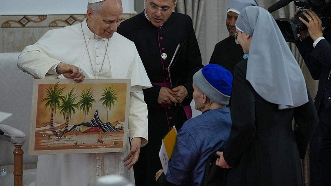 Pope Leo XIV is presented with a gift during his visit to the nursing home of the Little Sisters of the Poor in Annaba, Algeria, on Tuesday, the second day of an 11-day apostolic journey to Africa.