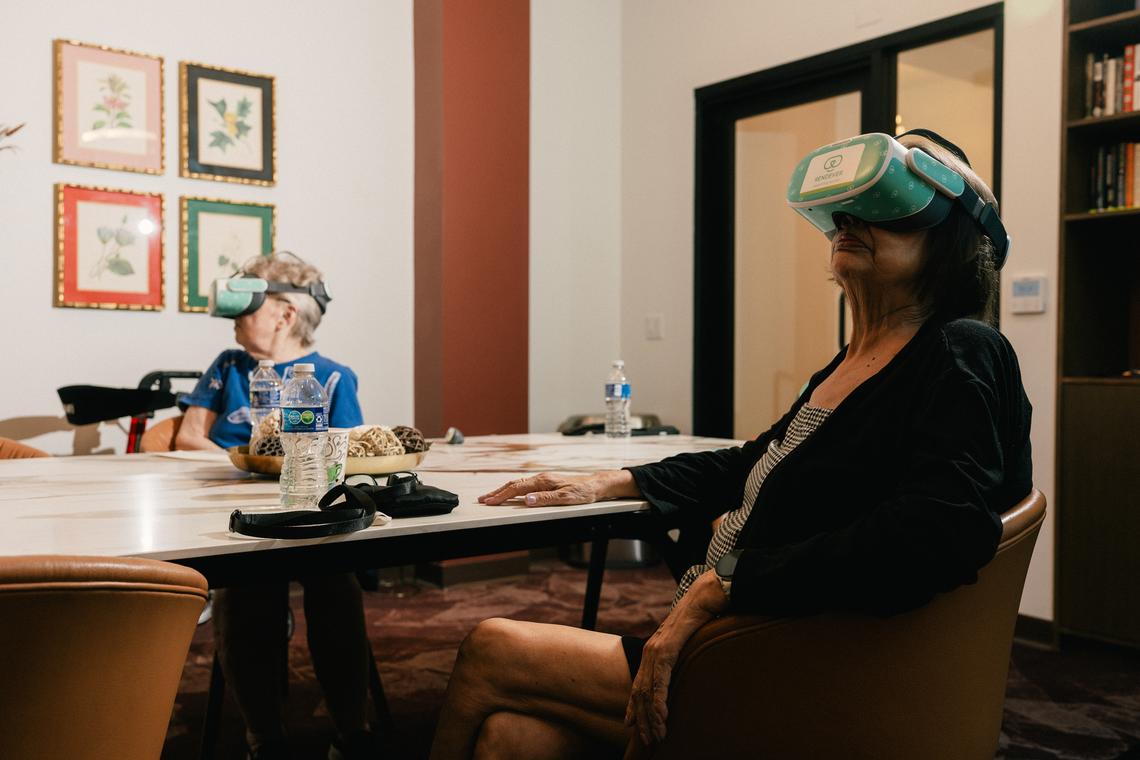 Pat Bridges, left, and Mary Sue Escamilla, right, watch a Barcelona travel video with VR headsets in the multi-purpose library at Castle Argyle in Los Angeles, Feb. 2, 2026. New tools tailored for use in senior living communities allow for shared experiences and social bonding. (Morgan Lieberman/The New York Times)