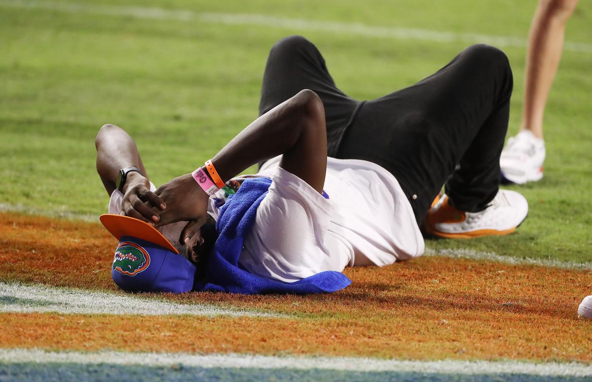 An unknown Florida fan lies on the field after Florida lost, 18-16, against USF at Ben Hill Griffin Stadium in Gainesville, Florida, on Saturday, Sept. 6, 2025. (Stephen M. Dowell/Orlando Sentinel/TNS)
