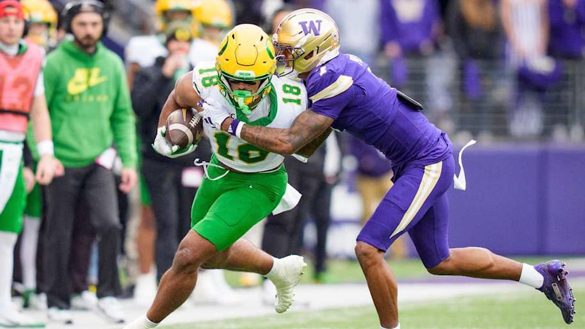  Oregon tight end Kenyon Sadiq carries the ball under cover from Washington cornerback Ephesians Prysock as the Oregon Ducks take on the Washington Huskies on Nov. 29, 2025, at Husky Stadium in Seattle, Washington. | Ben Lonergan/The Register-Guard / USA TODAY NETWORK via Imagn Images 