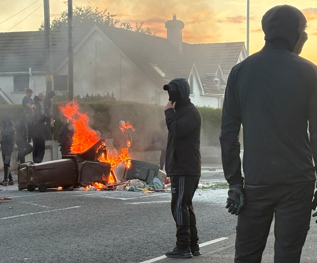 A fire burns in bins as anti-immigrant protesters clash with police at Antrim road, following a knife attack on June 8, which left a man seriously injured and prompted police to declare a critical incident, in Belfast, Northern Ireland, June 10, 2026. Picture taken with a phone. REUTERS/Isabel Infantes