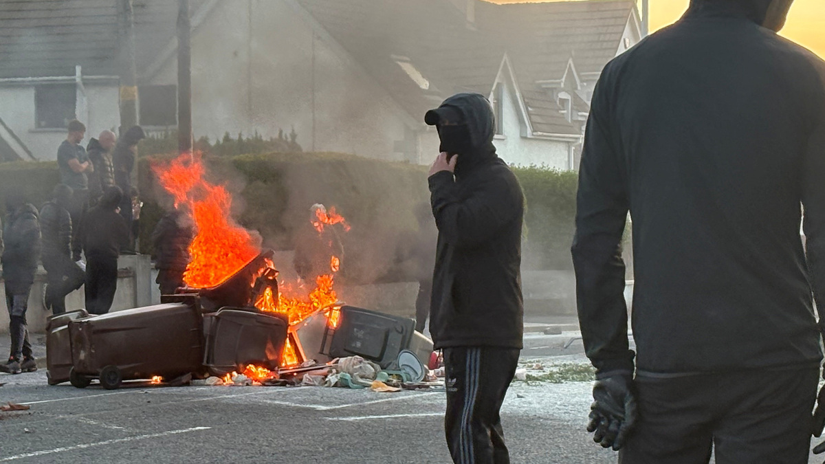 A fire burns in trash bins as anti-immigrant protesters clash with police following a knife attack on Monday, which left a man seriously injured and prompted police to declare a critical incident, in Belfast, Northern Ireland, on Wednesday.