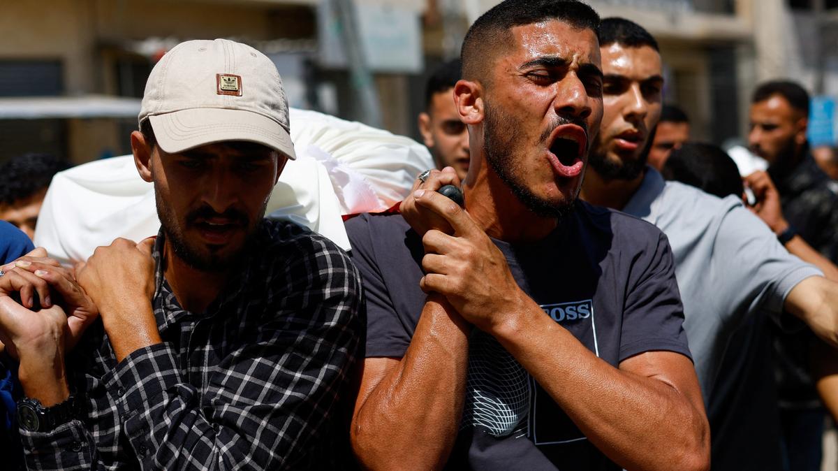 People carry bodies identified by mourners as Hamas' military wing commander Mohammad Odeh, who was killed in an Israeli strike on Tuesday, and his wife and children during a funeral in Gaza City on Wednesday.