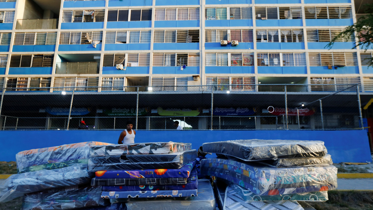 A person watches over mattresses outside a building that was deemed too damaged and whose residents were evacuated after deadly earthquakes struck the country, in Caracas, Venezuela, June 27, 2026. REUTERS/Fausto Torrealba