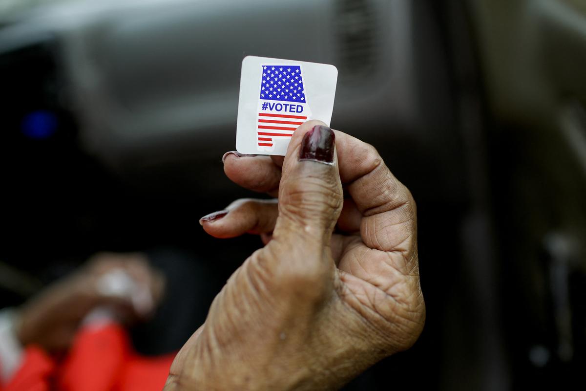  Sadie Janes shows off her voting sticker after casting her ballot at Floyd Middle Magnet School during the Democratic presidential primary in Montgomery, Alabama on Super Tuesday, March 3, 2020. 