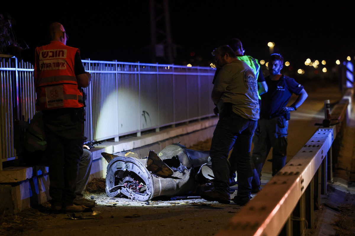 Israeli security and rescue personnel work next to a part of a projectile following a missile attack from Iran towards Israel in northern Israel, June 8, 2026. REUTERS/Shir Torem