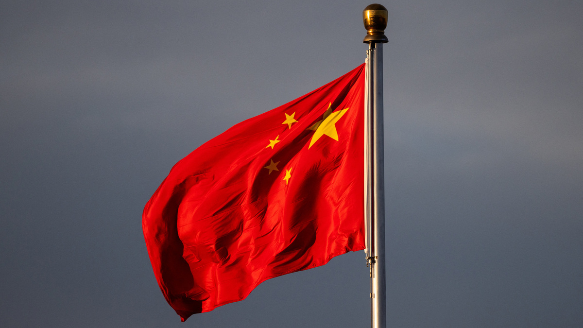 China’s national flag flutters in the wind lit by sunrise in Beijing, China, November 20, 2025. REUTERS/Maxim Shemetov