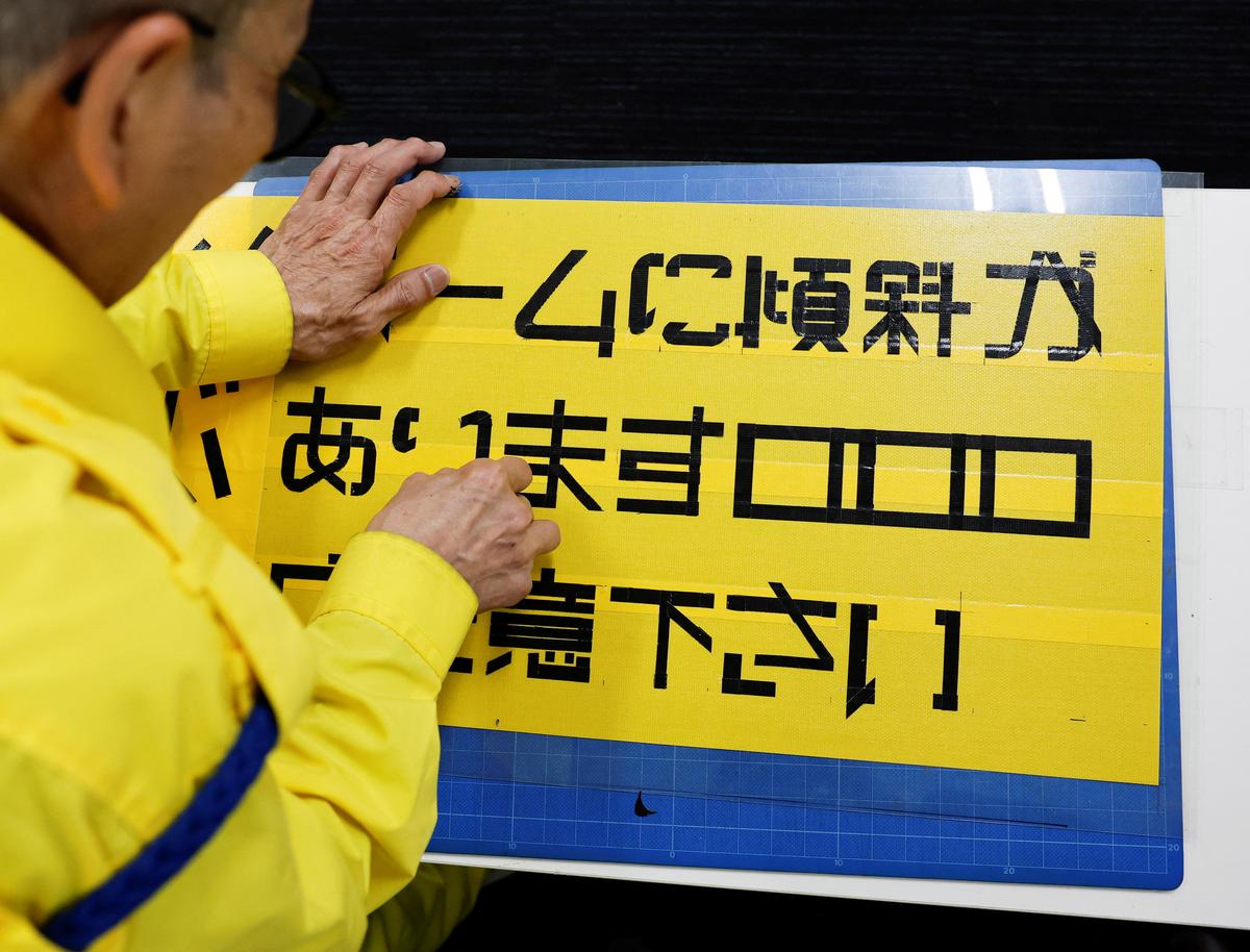 Shuetsu Sato, a security guard whose handmade duct-tape signs have gained widespread recognition, makes a duct-tape sign at a security company office where he works, in Tokyo, Japan, May 1, 2026.   REUTERS/Kim Kyung-Hoon
