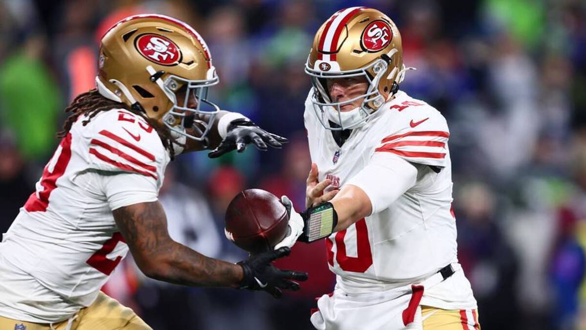  Jan 17, 2026; Seattle, WA, USA; San Francisco 49ers quarterback Mac Jones (10) hands off to running back Jordan James (29) against the Seattle Seahawks during the second half in an NFC Divisional Round game at Lumen Field. Mandatory Credit: Kevin Ng-Imagn Images | IMAGN IMAGES via Reuters Connect 