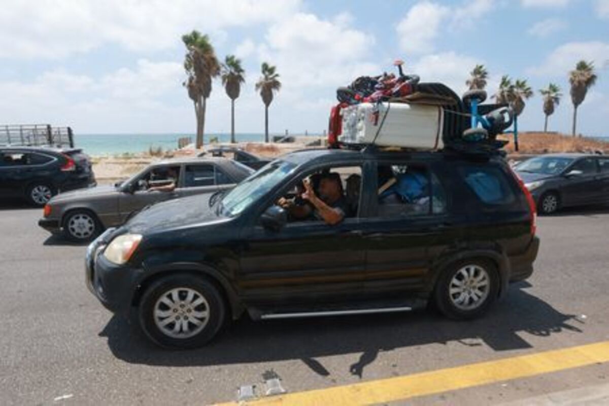 A man flashes victory sign out of a car as displaced people make their way back to their homes in southern Lebanon following an interim deal between the U.S. and Iran, in Sidon, Lebanon, June 24, 2026. REUTERS/Aziz Taher