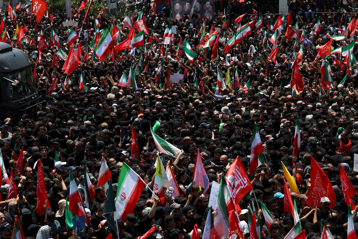 People march before a vehicle carrying coffins of Iran's late Supreme Leader Ayatollah Ali Khamenei and his family members, makes its way as people attend a funeral procession for Khamenei, who was killed on February 28 in Israeli and U.S. airstrikes, in Tehran, Iran, July 6, 2026. REUTERS/Murad Sezer