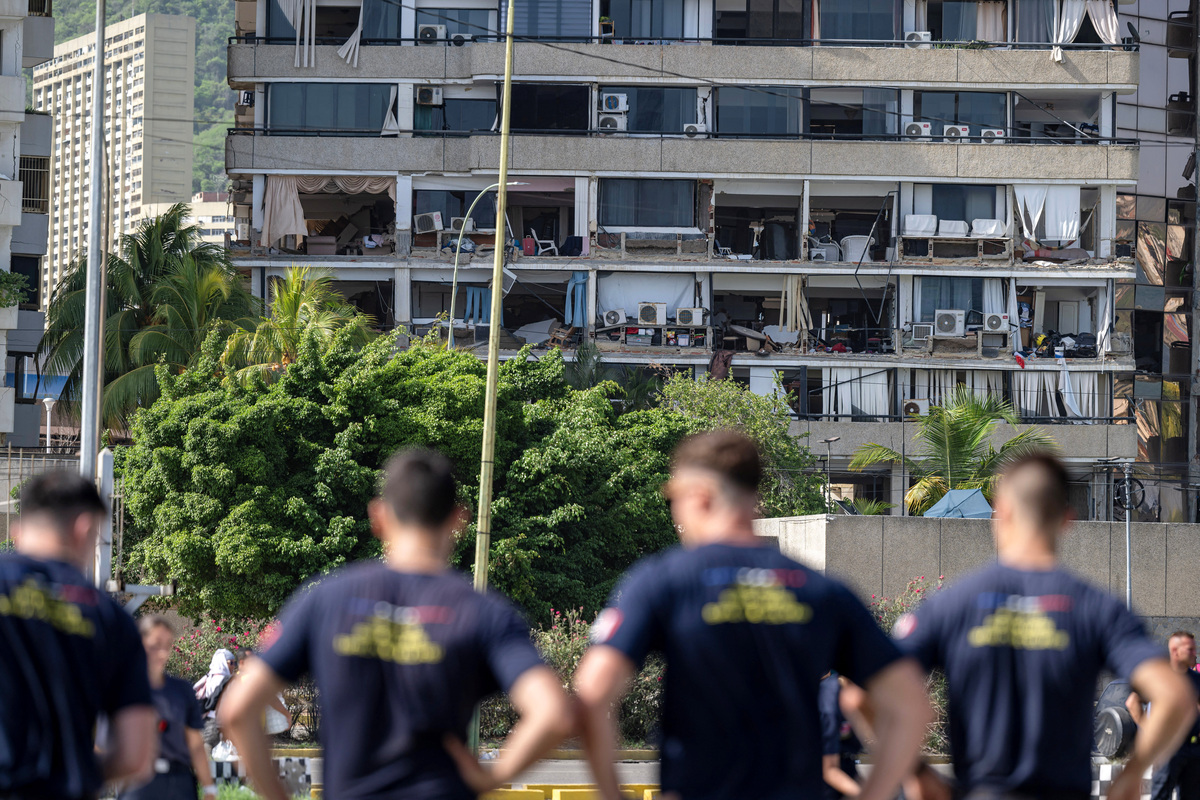 Members of the French Civil Security Training and Intervention Regiment (UIISC 7) look at a damaged building from their base camp at the Karting La Guaira complex in Caraballeda, La Guaira state, Venezuela, on June 27, 2026, as they assist with rescue operations following earthquakes. MIGUEL MEDINA/Pool via REUTERS