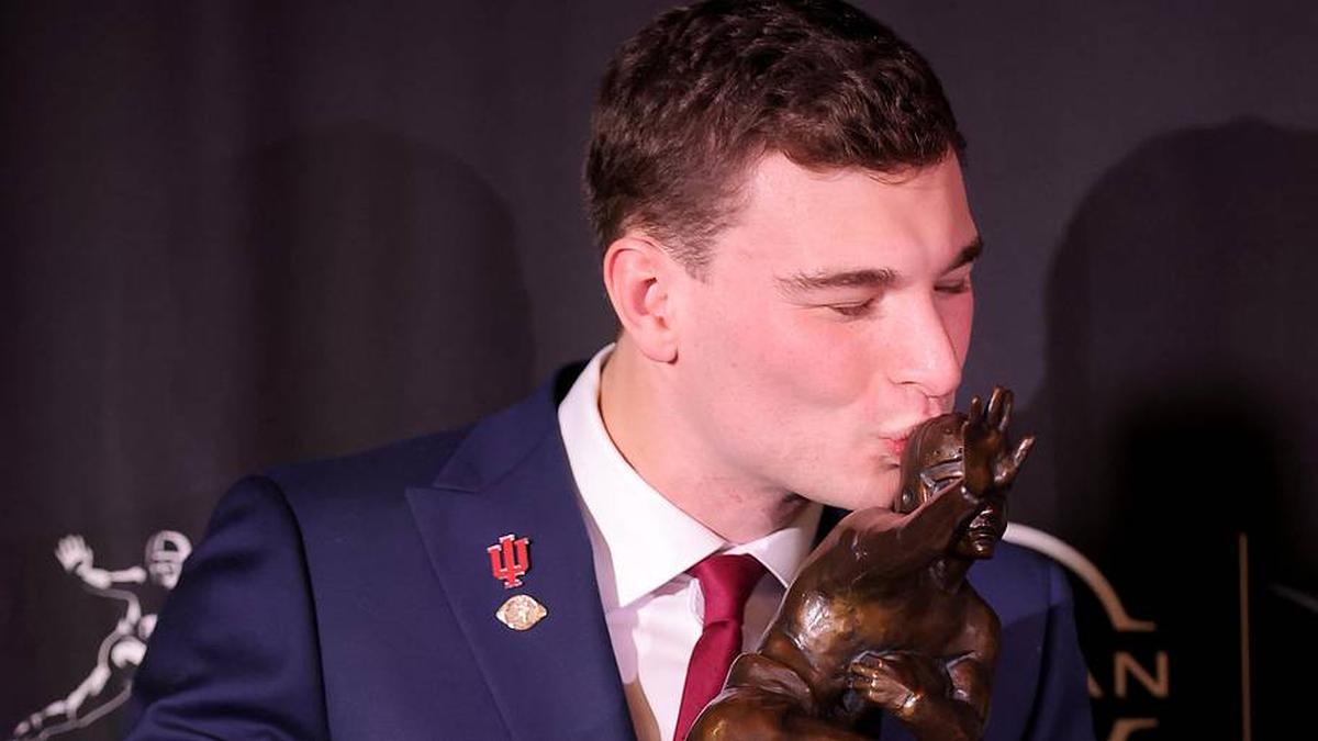  Dec 13, 2025; New York, NY, USA; Indiana Hoosiers quarterback Fernando Mendoza kisses the Heisman trophy during a press conference at the New York Marriott Marquis after winning the award. Mandatory Credit: Brad Penner-Imagn Images | Brad Penner-Imagn Images 