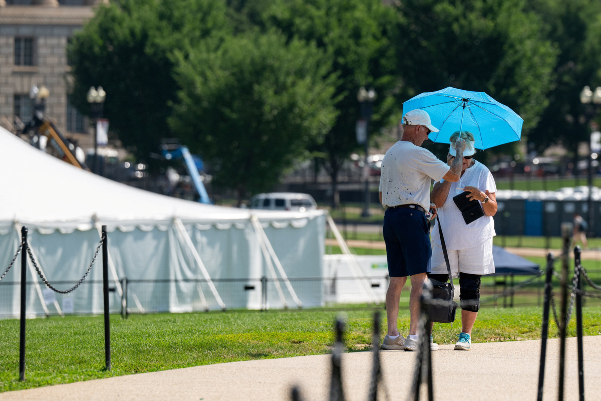 Tourists use an umbrella to block the sun as excessive heat hits Washington, D.C., U.S., July 1, 2026. REUTERS/Annabelle Gordon