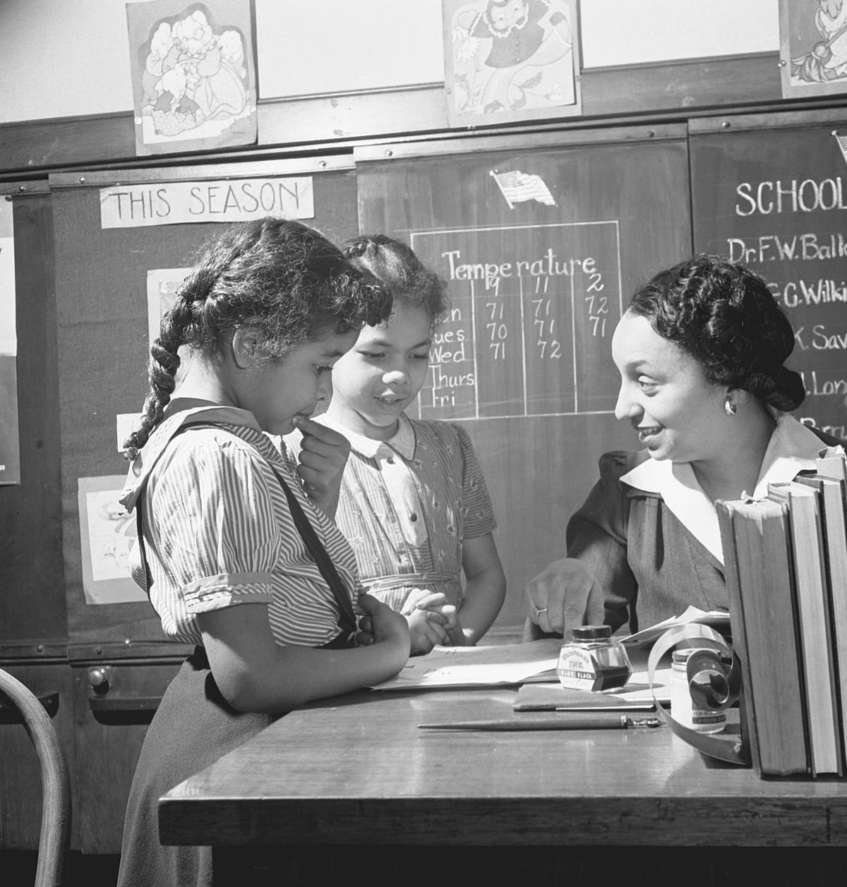  A teacher talks with students at an elementary school for Black children in 1942. Buyenlarge/Getty Images 