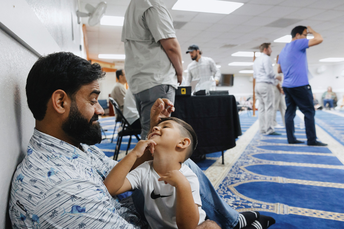 Naseer Ahmad Paktiawal holds Abubakar Paktiawal, 2, son of his brother Mohammad Nazeer Paktiawal, who died in ICE custody, while attending a town hall meeting held by AfghanEvac, an advocacy organization for Afghans who helped the U.S. military, at the Abu Hanifa Mosque in Richardson, Texas, U.S. June 4, 2026.  REUTERS/Shelby Tauber