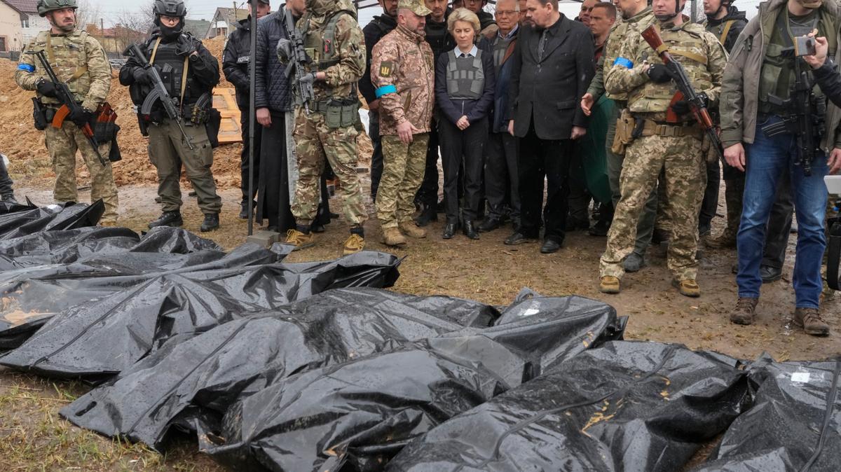 EU Commission President Ursula von der Leyen, center, looks at covered bodies of killed civilians in Bucha, on the outskirts of Kyiv, Ukraine, on Friday.