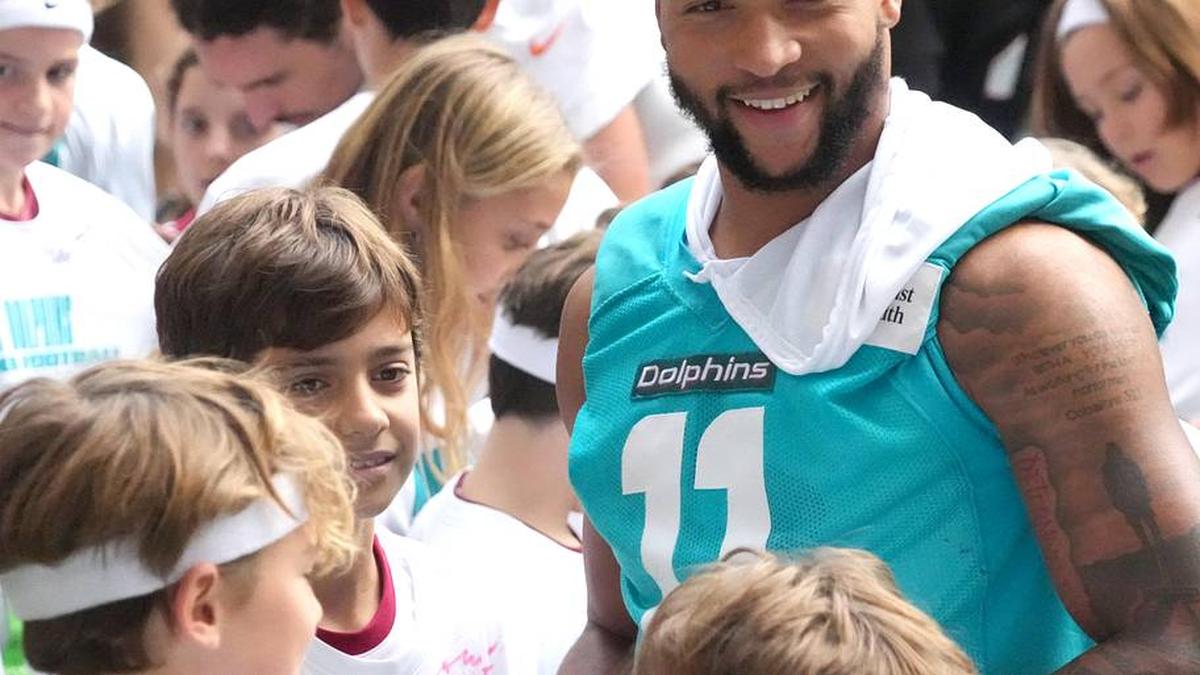  Nov 14, 2025; Madrid, Spain; Miami Dolphins safety Dante Trader Jr. (11) interacts with community flag football conic participants at Estadio Riyadh Air Metropolitano. Mandatory Credit: Kirby Lee-Imagn Images | Kirby Lee-Imagn Images 