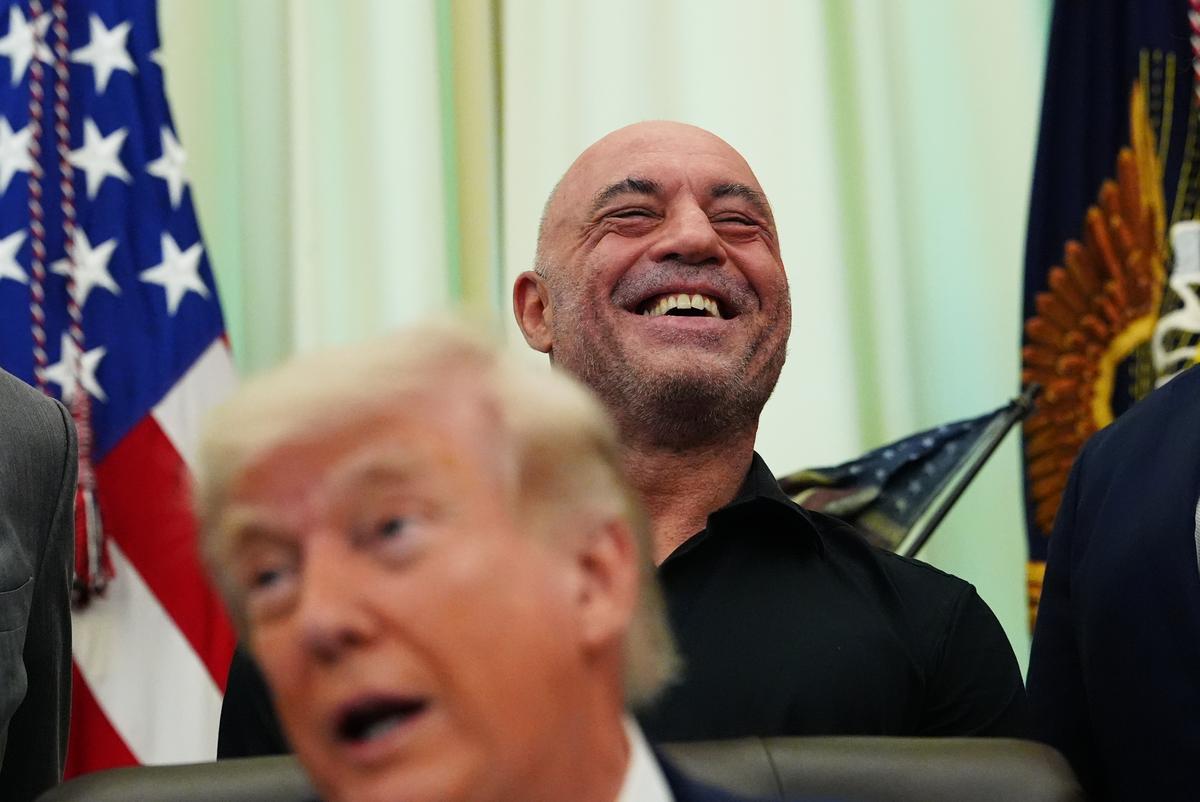  Joe Rogan laughs as President Donald Trump speaks in the Oval Office of the White House on April 18, 2026, in Washington. 