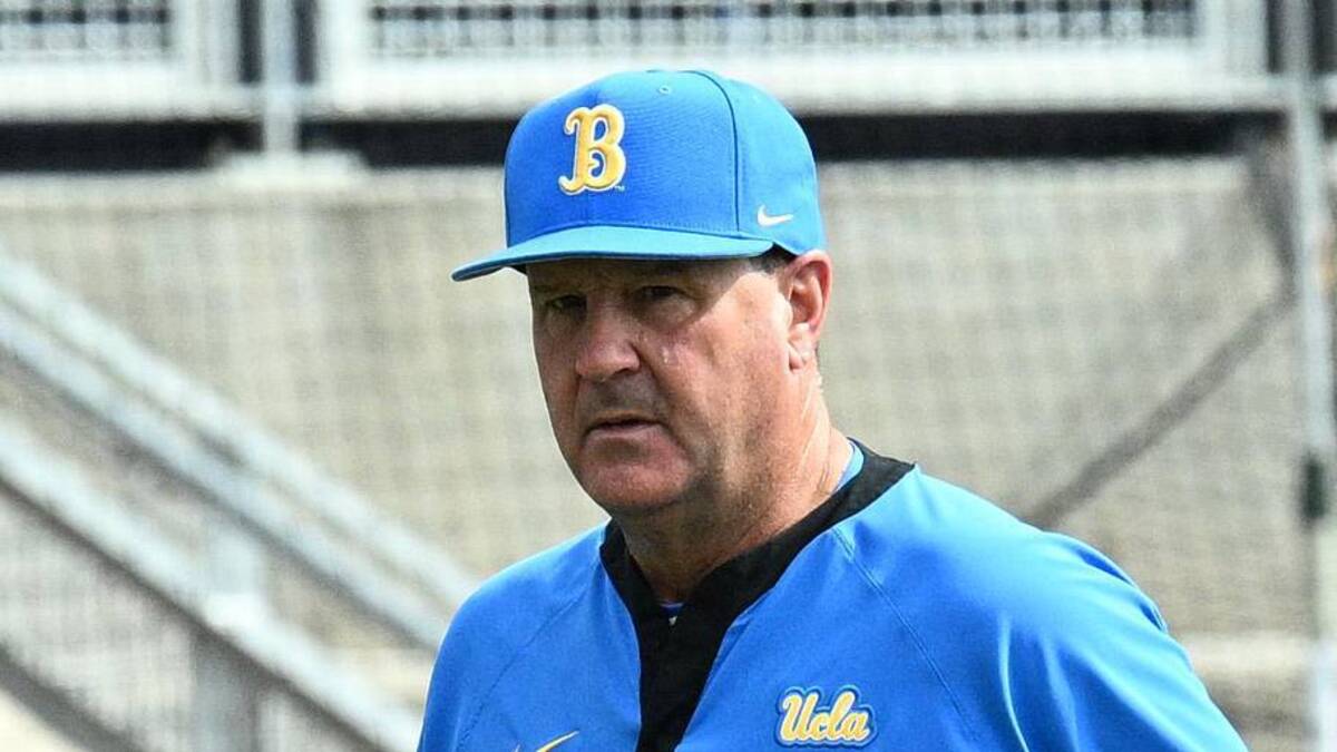  Jun 17, 2025; Omaha, Neb, USA; UCLA Bruins head coach John Savage (22) walks to the dugout before the restart of the game against the LSU Tigers at Charles Schwab Field. Mandatory Credit: Steven Branscombe-Imagn Images | Steven Branscombe-Imagn Images 