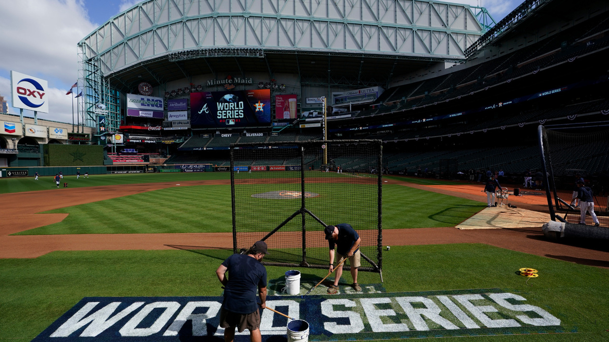 Stadium workers paint the logo on the field Monday, Oct. 25, 2021, in Houston, in preparation for Game 1 of baseball’s World Series tomorrow. (AP Photo/David J. Phillip)