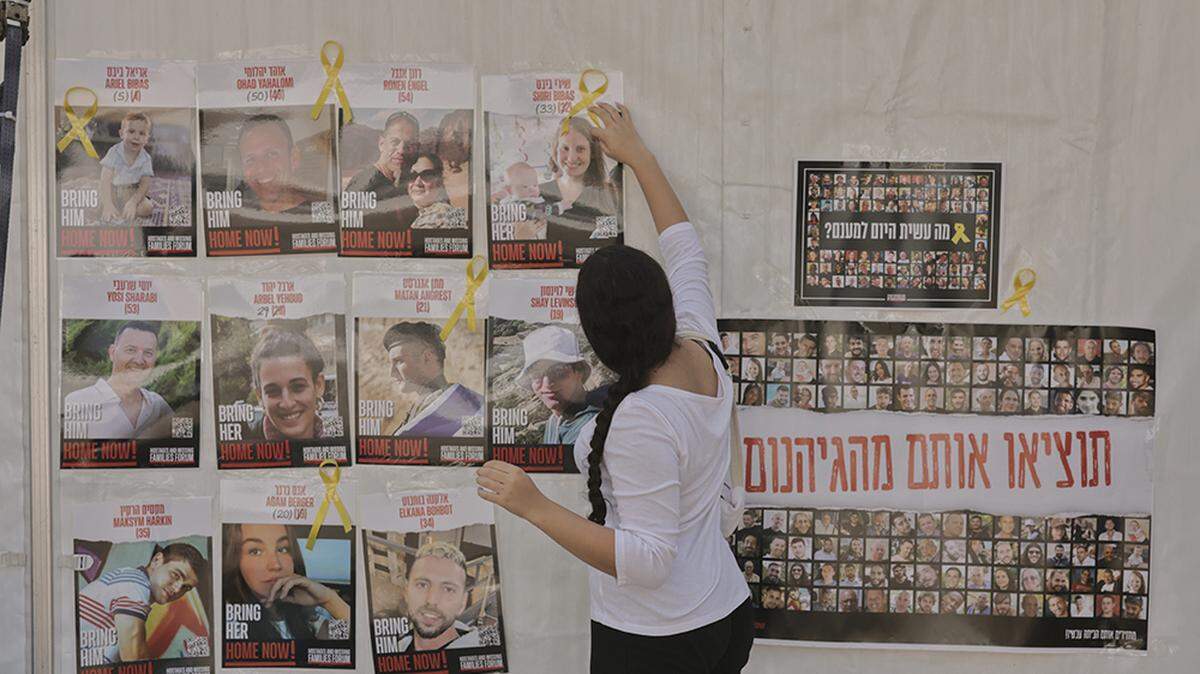 Una mujer coloca cintas amarillas en carteles de los desaparecidos en la “Plaza de los Rehenes” en Tel Aviv, Israel, el jueves. Israel aún no había convocado a los ministros del gabinete para discutir la ratificación formal de una propuesta de alto el fuego con Hamás; sin embargo, el primer ministro Benjamin Netanyahu dijo que se habían resuelto las discrepancias y ordenó que el gabinete se reuniera el viernes para aprobar el acuerdo.