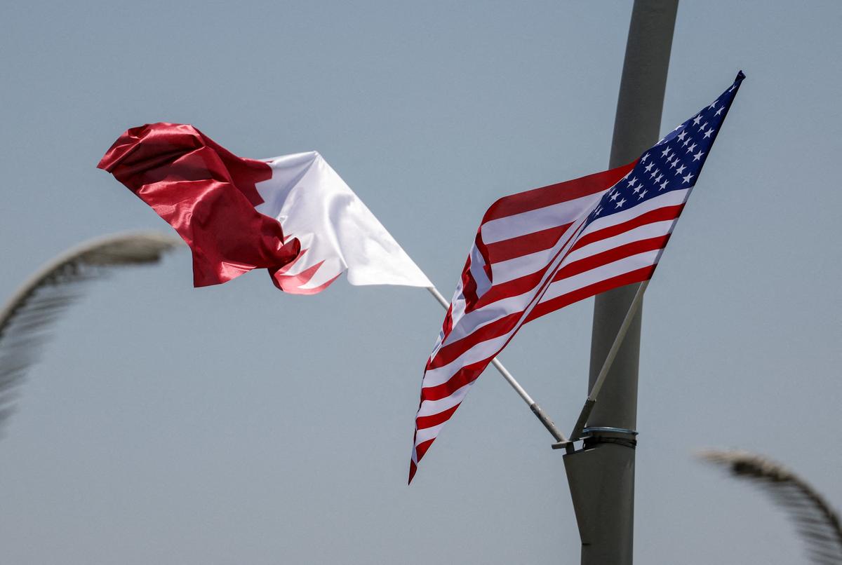 FILE PHOTO: U.S. and Qatar flags are seen on a lamppost ahead of the arrival of U.S. President Donald Trump in Doha, Qatar May 13, 2025. REUTERS/Ibraheem Abu Mustafa/File Photo