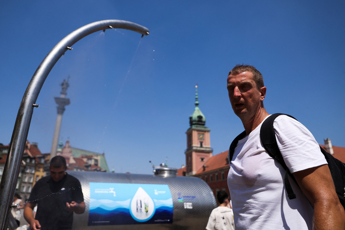 A man cools off under a water curtain as record temperatures hit Poland, in Warsaw, Poland, June 28, 2026. REUTERS/Kuba Stezycki