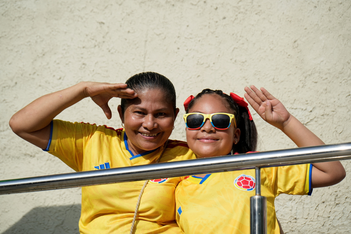Dos personas saludan junto a un colegio electoral en la segunda vuelta de las elecciones presidenciales en Barranquilla (Colombia). 21 junio 2026. REUTERS/Charlie Cordero