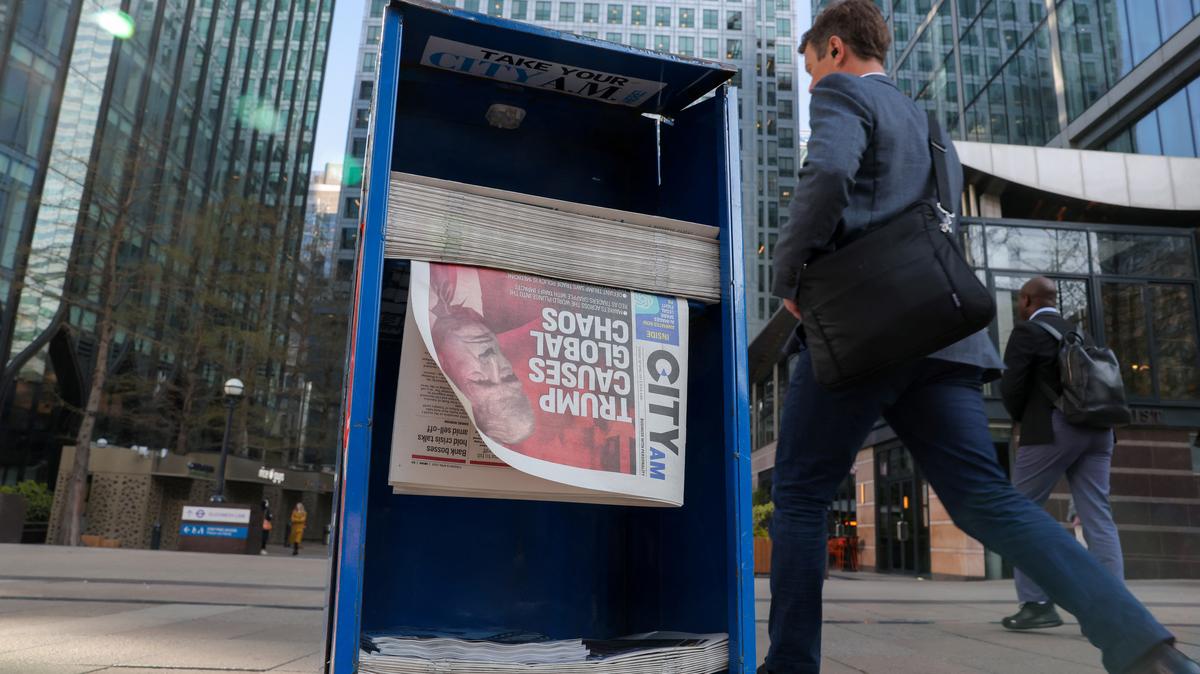 A man walks past a newspaper stand in the financial district of Canary Wharf following U.S. President Trump's firm stance on implementing his sweeping tariff plans in London, Britain, April 8, 2025.   REUTERS/Kevin Coombs