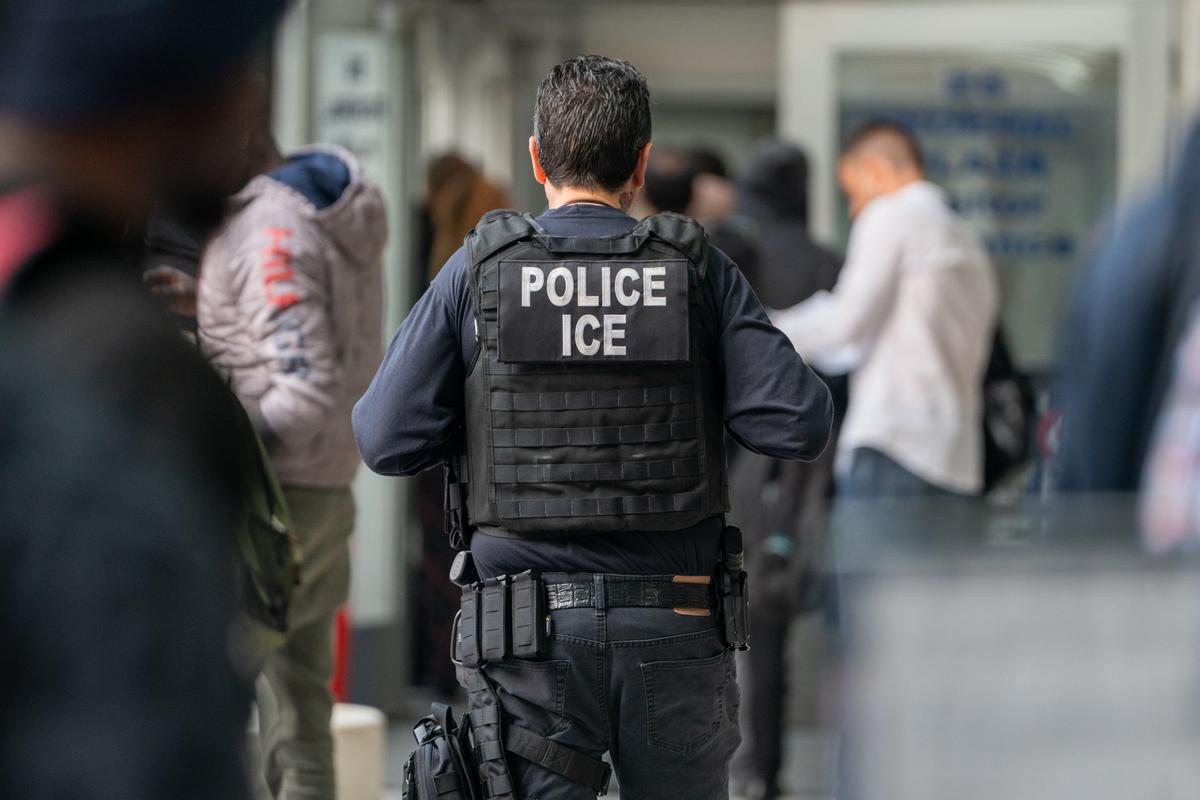 A US Immigration and Customs enforcement agent monitors asylum seekers in New York City on June 6, 2023.
