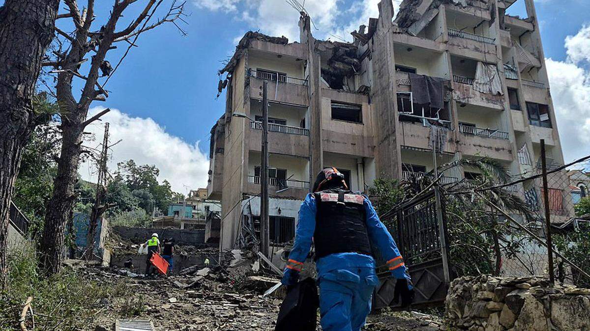 Lebanese rescue workers walk towards the site of an Israeli air raid on the southern town of Nabatieh on Monday. Israel will intensify its strikes against militant group Hezbollah, Prime Minister Benjamin Netanyahu said Monday.
