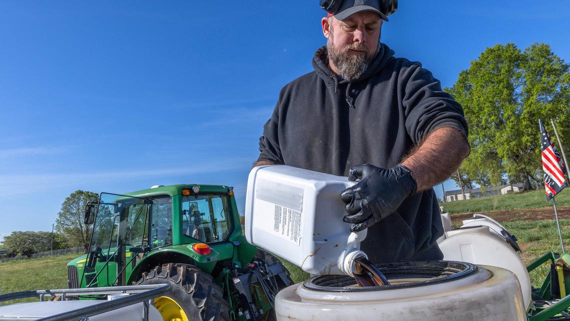 Co-Owner of Soil Regen and first generation farmer, Russell Hedrick, prepares a blend of minerals, biologicals, and fertilizers to be sprayed onto his fields while they are being seeded in Hickory, North Carolina, on April 10, 2026. US farmers are facing a double whammy of soaring fertilizer and diesel prices after US-Israeli strikes on Iran triggered Tehran's blockage of the Strait of Hormuz, a critical waterway for such shipments. (Grant Baldwin/AFP/Getty Images/TNS)
