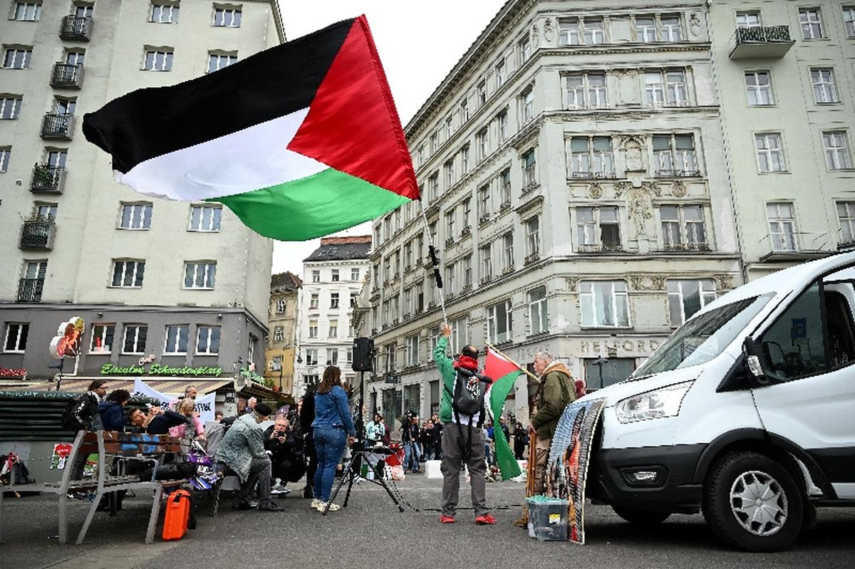 A person holds a Palestinian flag during a protest against the participation of Israel at the Eurovision Song Contest in Vienna, Austria, May 12, 2026. REUTERS/Elisabeth Mandl