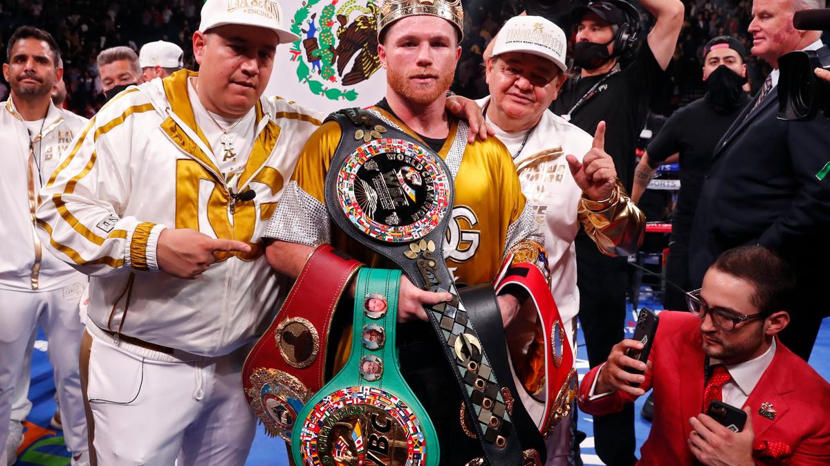 Canelo Alvarez, of Mexico, poses with the belts after defeating Caleb Plant in a super middleweight title unification fight Saturday, Nov. 6, 2021, in Las Vegas. (AP Photo/Steve Marcus)
