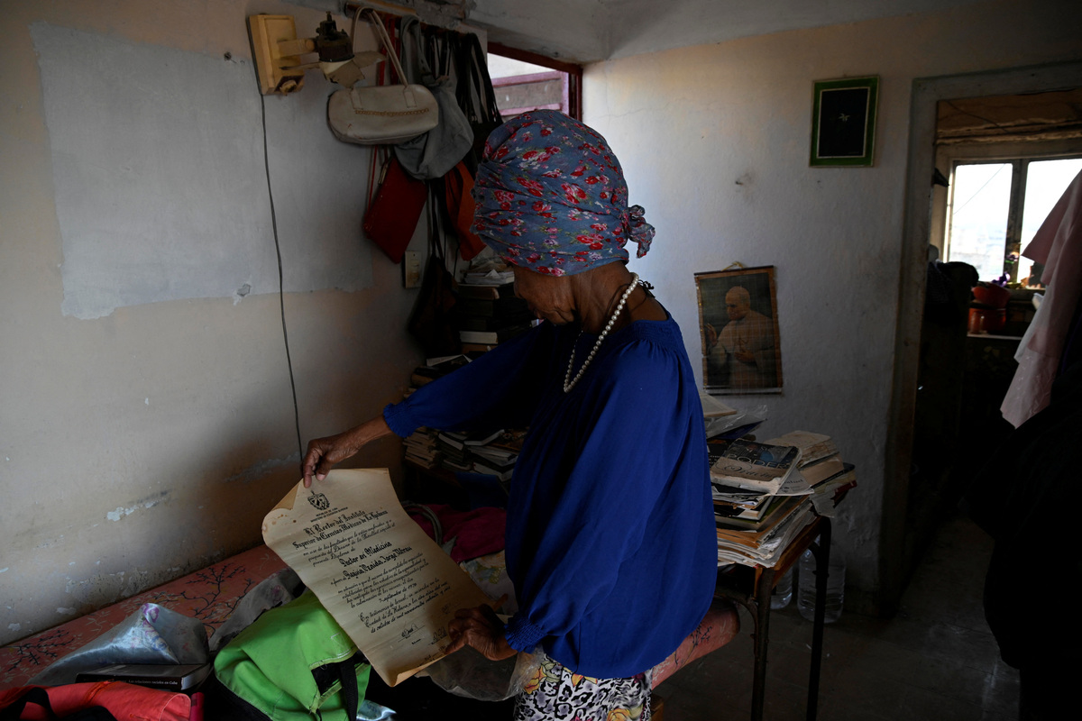 Regina Zaida Jorge, 74, a pensioner who lives alone and relies on church groups for food, shows her medical diploma at her home in Havana, Cuba, April 29, 2026. Jorge said she had given "everything" as a low-paid state worker to a system incapable of providing her with necessities as basic as a bar of soap. REUTERS/Norlys Perez