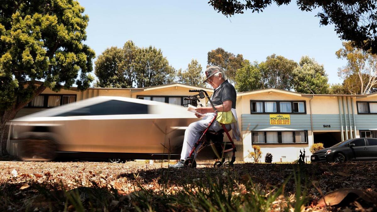 LOS ANGELES, CA - June 17, 2026: Local resident Miguel Lopez reads a book on a patch of public land along San Vicente Boulevard as traffic zooms past him in Los Angeles on Wednesday, June 17, 2026. The San Vicente Park Foundation has a plan to turn that stretch of their neighborhood into a greenway. (Christina House / Los Angeles Times)