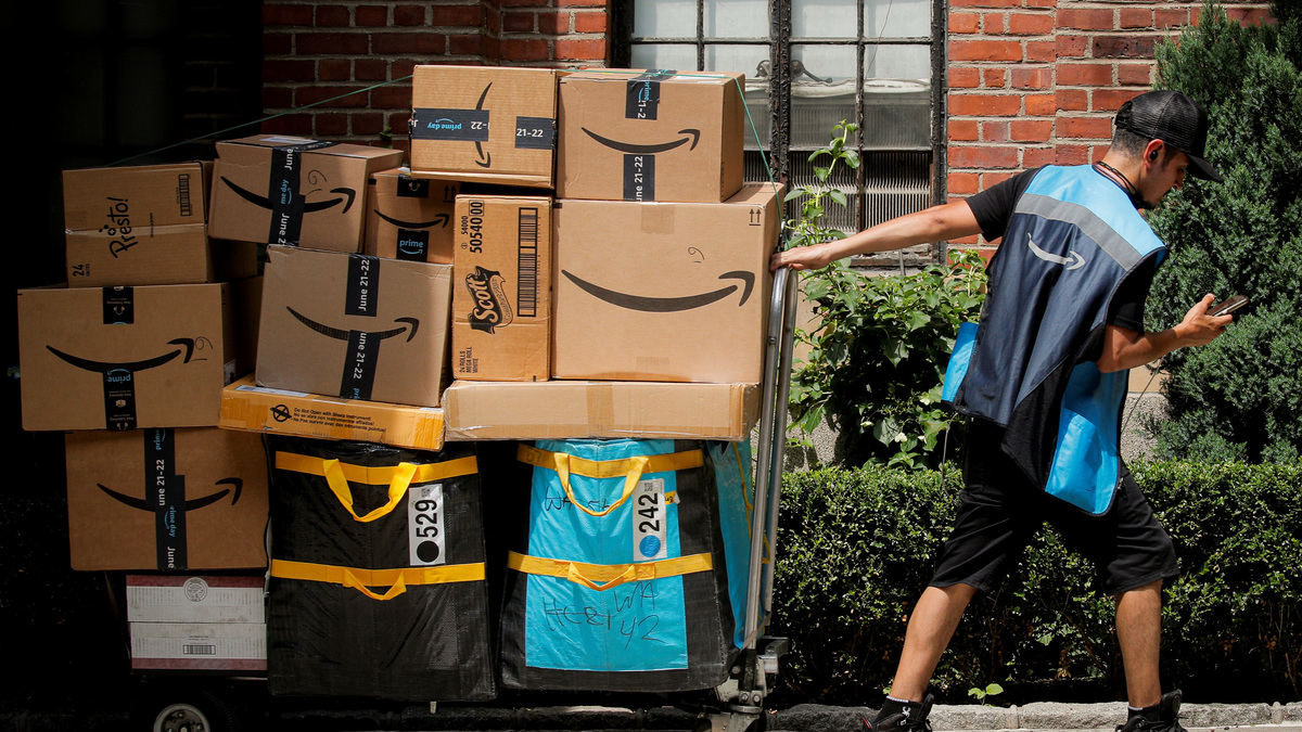 An Amazon delivery worker pulls a delivery cart full of packages during its annual Prime Day promotion in New York City, U.S., June 21, 2021.  REUTERS/Brendan McDermid