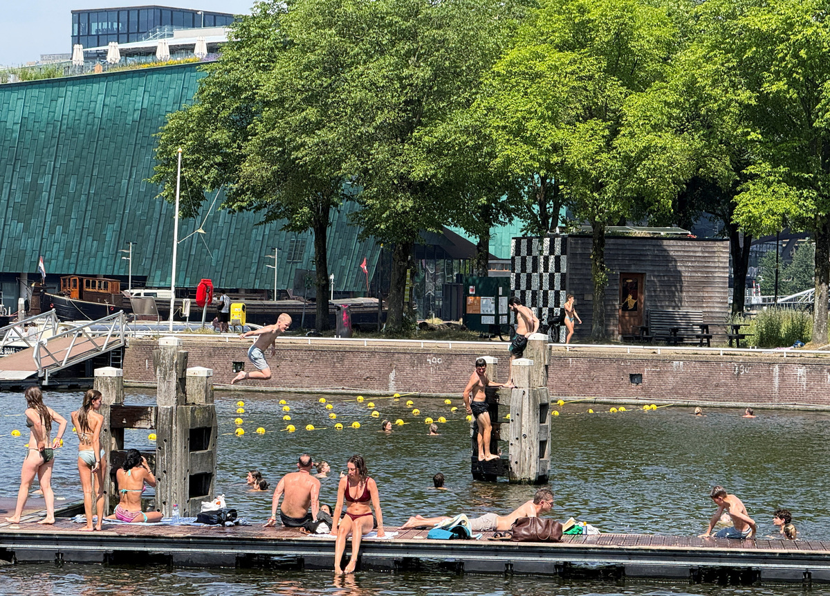 People enjoy a swimming spot in Amsterdam, The Netherlands, where a rare red alert was issued for Friday during the ongoing heatwave in the country, June 26, 2026. Picture taken with a mobile phone. REUTERS/Charlotte Van Campenhout