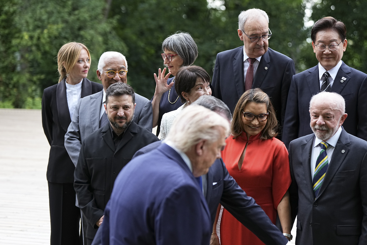 President Volodymyr Zelenskyy of Ukraine, left, watches as President Donald Trump arrives for a group photo during a cultural performance event at the G7 Summit in Evian-les-Bains, France, June 16, 2026. (Haiyun Jiang/The New York Times)