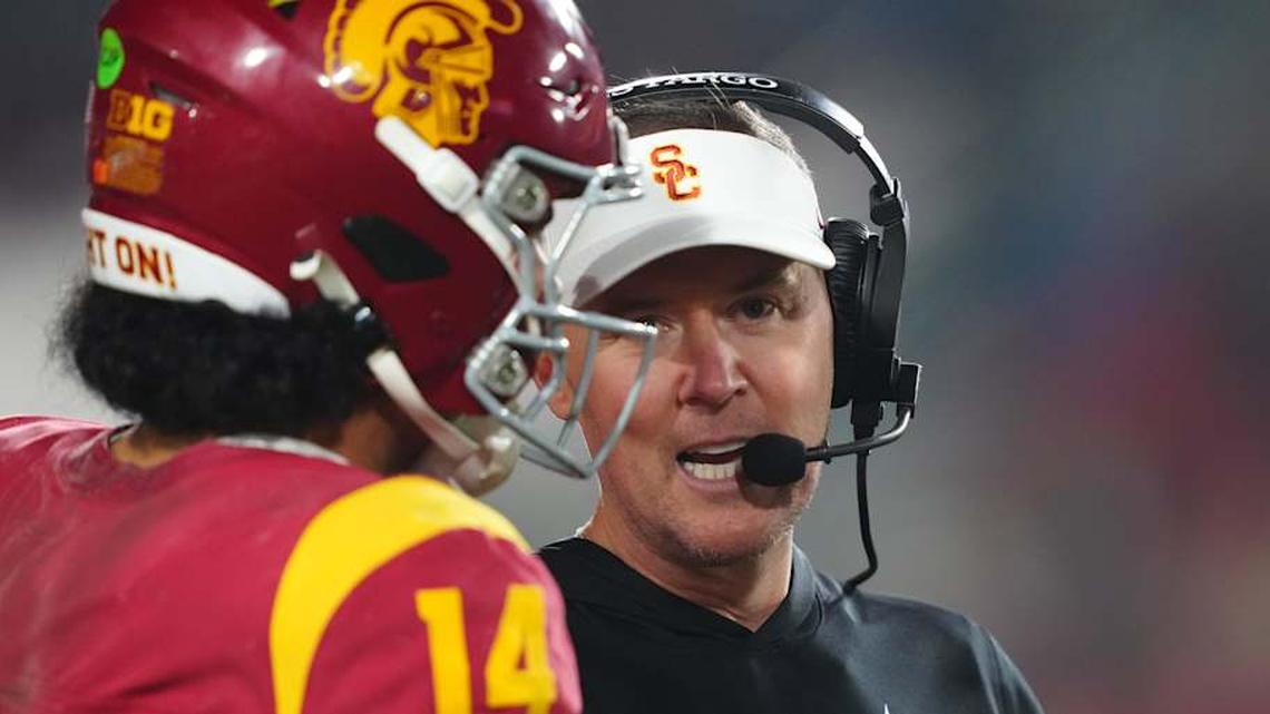  Nov 29, 2025; Los Angeles, California, USA; Southern California Trojans head coach Lincoln Riley (right) talks with quarterback Jayden Maiava (14) in the second half against the UCLA Bruins at United Airlines Field at Los Angeles Memorial Coliseum. Mandatory Credit: Kirby Lee-Imagn Images | Kirby Lee-Imagn Images 