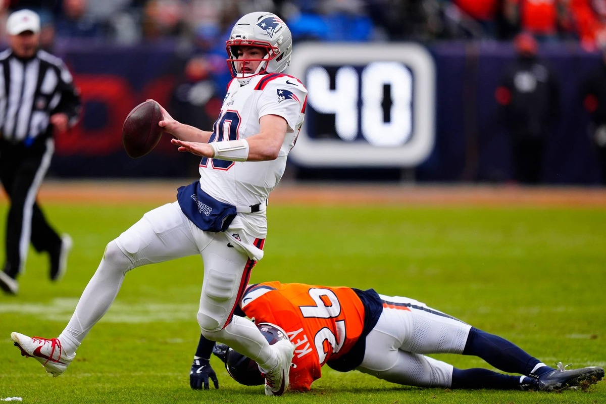  Jan 25, 2026; Denver, CO, USA; New England Patriots quarterback Drake Maye (10) rushes the ball against Denver Broncos safety Devon Key (26) during the first half in the 2026 AFC Championship Game at Empower Field at Mile High. Mandatory Credit: Ron Chenoy-Imagn Images