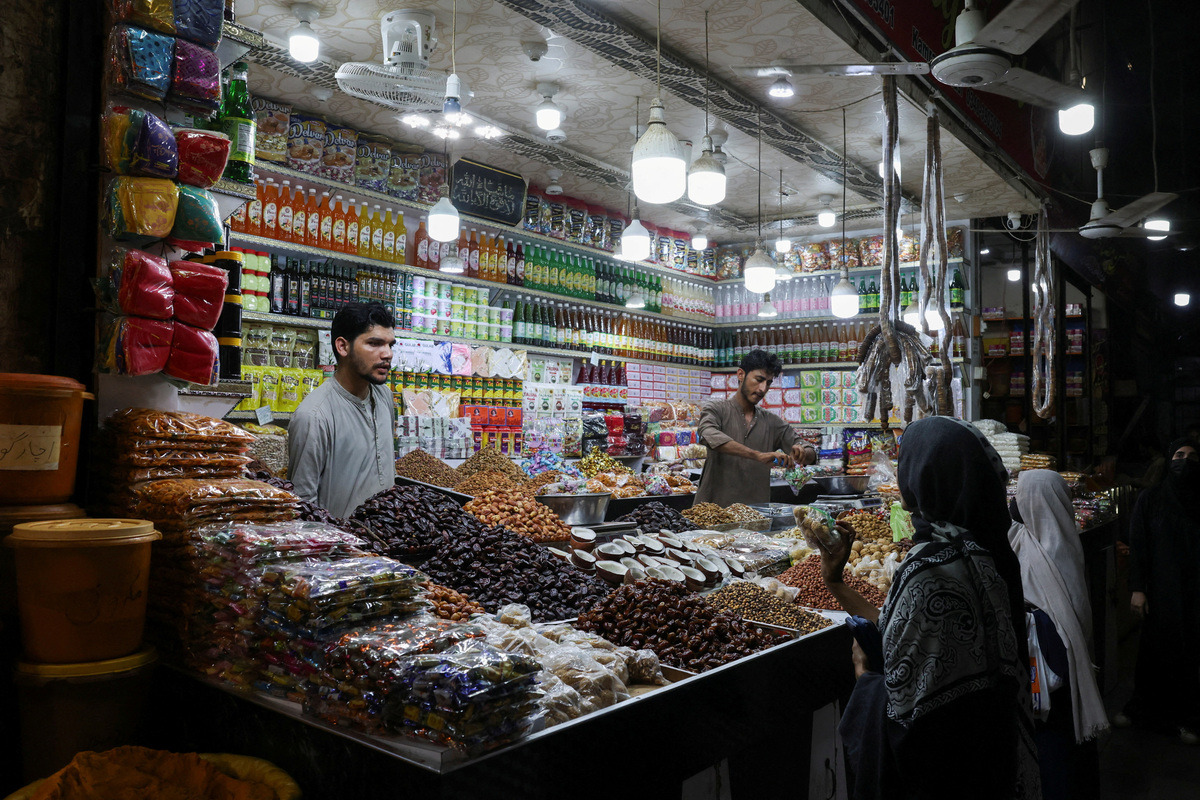 FILE PHOTO: Shopkeepers serve customers at a dry fruit and grocery shop in Karachi, Pakistan June 2, 2026. REUTERS/Akhtar Soomro/File Photo