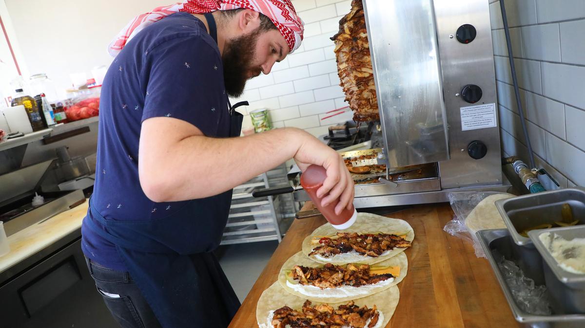 Chef Mohammad Abutaha creates shawarma wraps in his Oakland cafe. He also has a location in Santa Clara, where Jordan's team will compete in the World Cup. (Aric Crabb/Bay Area News Group)